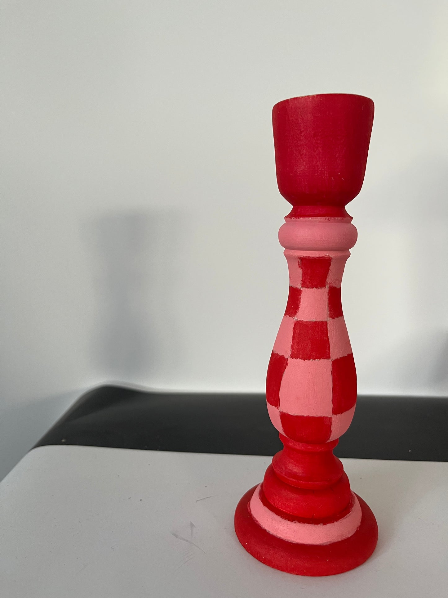 Red and pink checkered candlestick on a white background